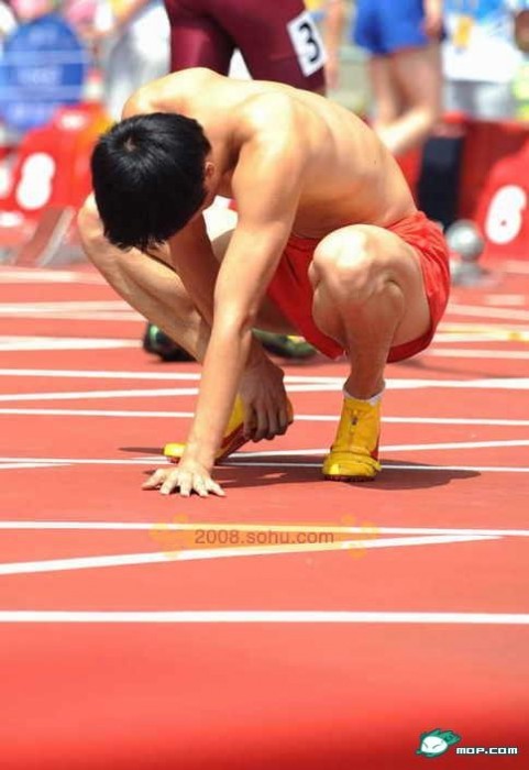 Liu Xiang crouched over in pain.