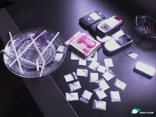 Drugs (kingfen, ketamine), RMB money, cell phones on coffee table.