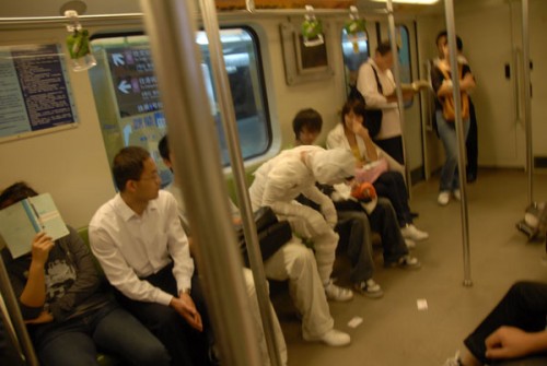 Shanghai metro mummy sits down with other passengers.