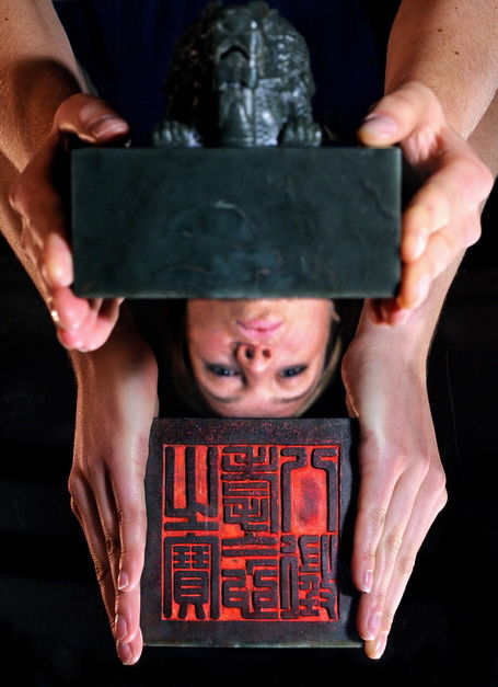 Auction house worker displaying the underside of the jade seal.