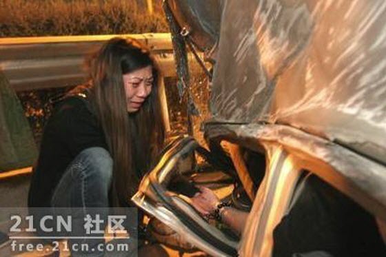 A young Chinese girl is seen crying, clutching the hand of her boyfriend, who is near death and trapped inside an overturned Chery QQ, begging him to hold on.
