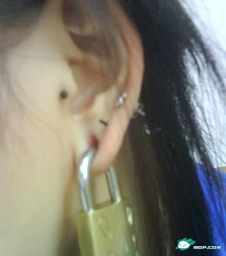 A Chinese schoolgirl wears a lock as an earring
