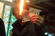 Chinese student lights a cigarette with a 100 RMB cash note.