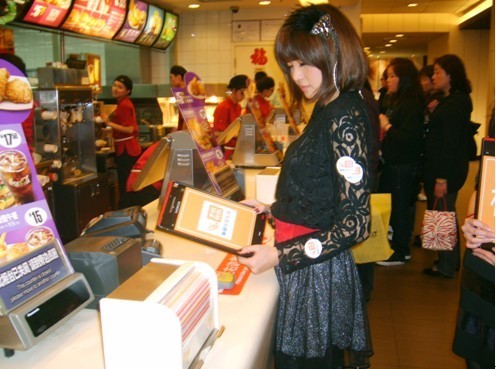 A Chinese promotions girl at the counter of McDonald's.