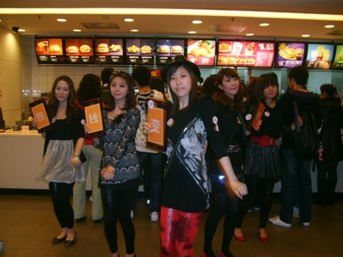 Five Chinese girls advertising "mobile phone wallet" dancing inside the Zhongshan Park McDonald's in Shanghai.