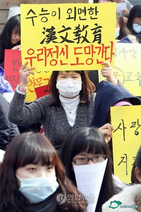 A Korean woman holds up a sign for Chinese character education.
