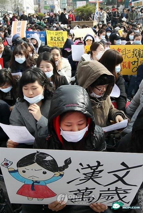 A Korean woman holds a sign for Chinese character education.
