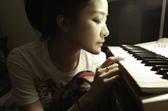 PixieTea (Zhang Xuanyan) beside piano keys.