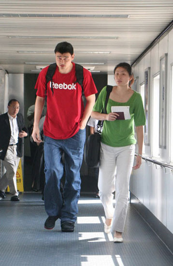 Yao Ming and Ye Li walking in airport.