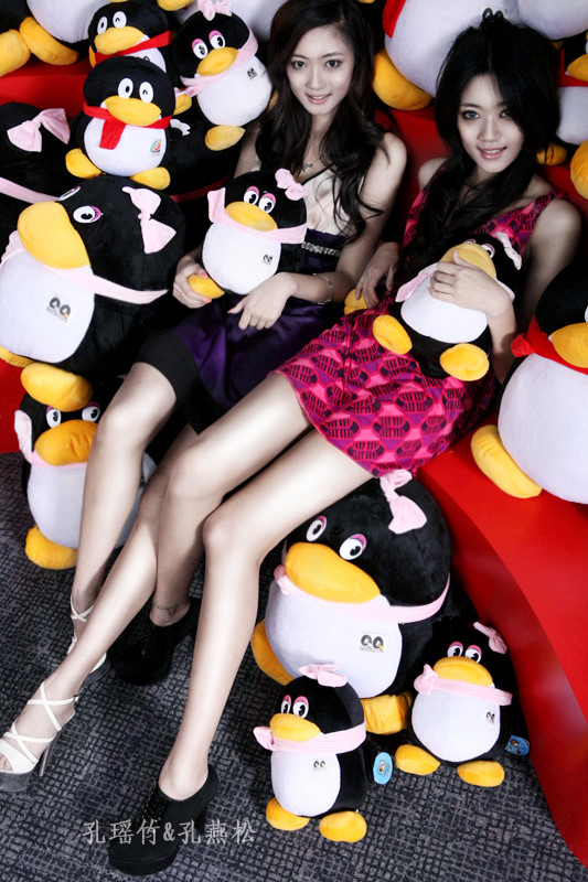 Kong Yansong and Kong Yaozhu, long-legged Chinese beauties, with the QQ penguin mascot.
