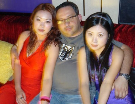 Man with Chinese girls in both arms.