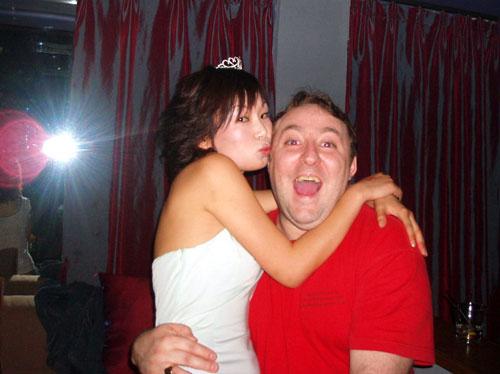 Happy white man with Chinese girl on lap.