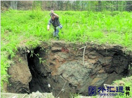 A Chinese man measures the depth of a sinkhole with string.