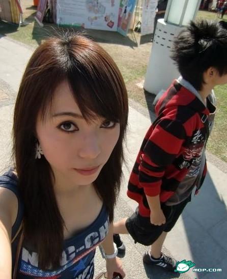 Chinese girl taking a self-photo on the street.