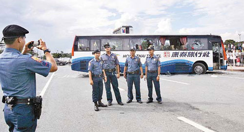 Philippine police taking photos in front of the Hong Kong tour bus that was involved in a hostage crisis.