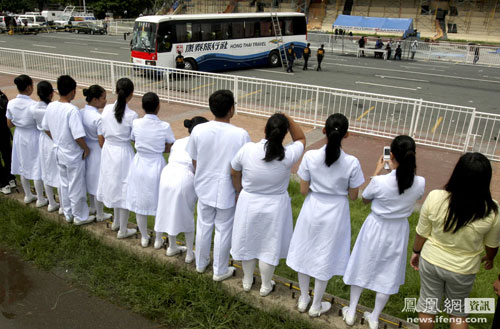 Filipino nurses and city residents looking on at the Hong Thai Travel tour bus where Hong Kong tourists were held hostage and later killed.