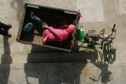 A mentally disabled man lies in a motorized tricycle.