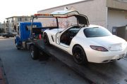 A white Mercedes Benz SLS being carried away on a flat-bed truck after its young Chinese owner was caught street racing in Surrey, Canada.