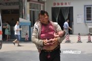 A mentally ill homeless Chinese woman carrying her naked newborn baby on the streets of Guangzhou.