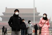 Chinese residents in Beijing wearing face masks due to the visible air pollution and poor air quality..