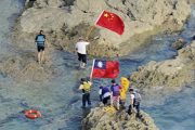 Chinese Diaoyu Island soverignty activists from Hong Kong swimming ashore onto Senkaku Island carrying PRC and ROC national flags.